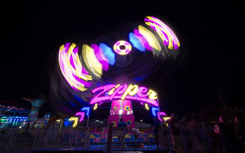 the zipper, a carnival ride, lit with a black background