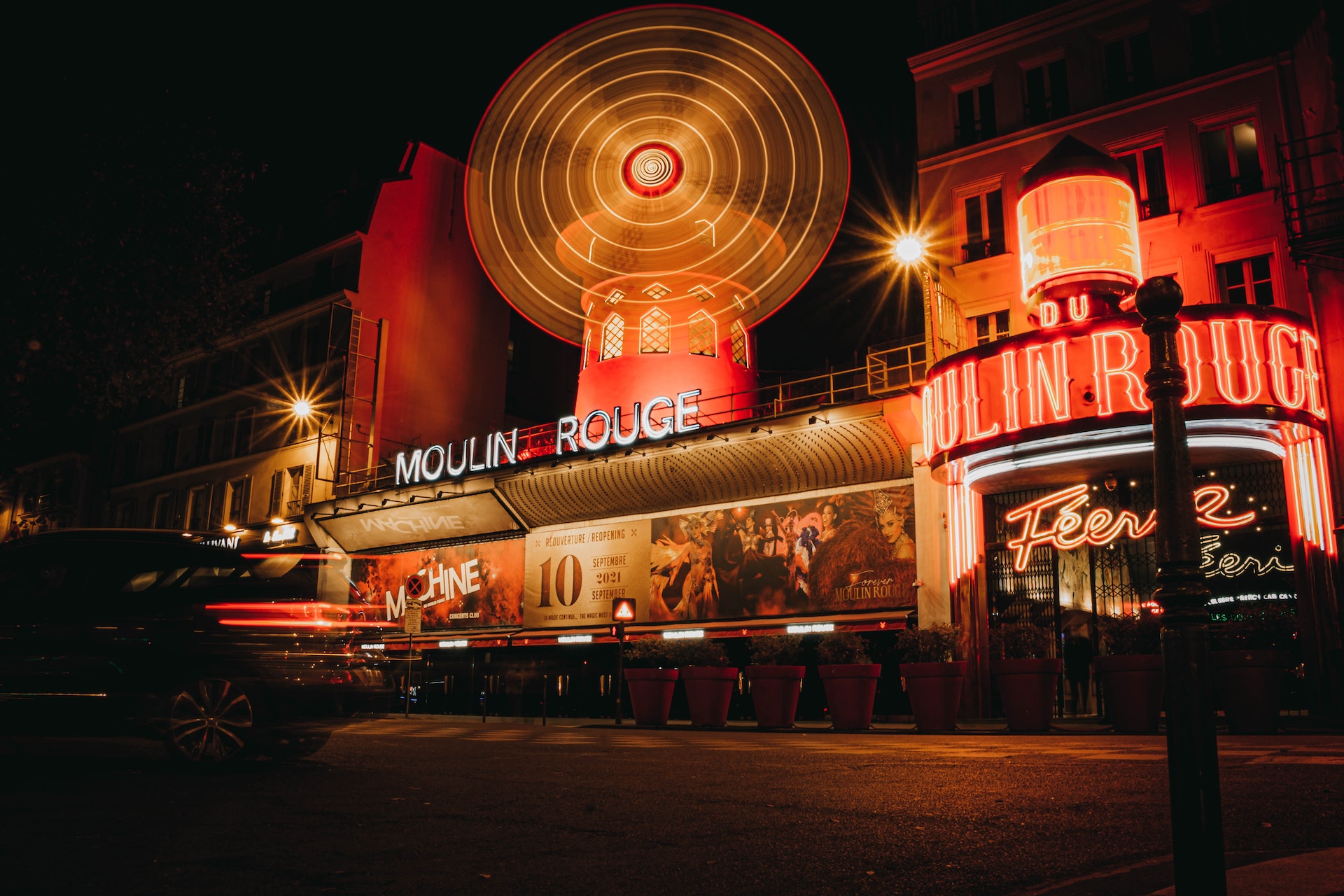 The Moulin Rouge at night -- sign in white letters underneath a large red windmill